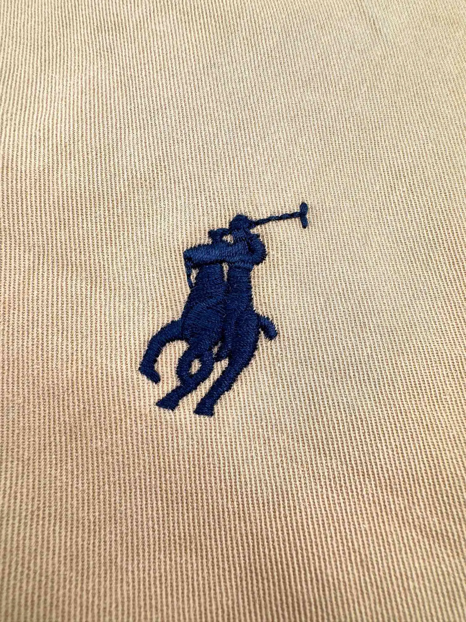 P520 Ralph Lauren embroidered zipper jacket. Customized elegant cotton fine twill fabric. Soft and silky. Comfortable against the skin. With khaki as the base color. Soft and unobtrusive. Just right to show a kind of restrained elegance. Exquisite pony logo embellished with it. Bringing an atmosphere of freedom and vitality. Injecting the soul charm of the brand. Simple and smooth lines outline a tall and straight figure. A unique and charming fashion masterpiece emerges. Process 1: Use imported machine embroidery process. Use advanced computer control systems and precision mechanical components to achieve the iconic pony embroidery operation with high precision and smooth and delicate lines. Process 2: Template machine bag opening. The preset template guides the position, shape and size of the bag opening. The accuracy ensures the quality of the bag opening effect. Process 3: Infrared positioning cutting bed uses infrared emitters and infrared receivers to achieve precise positioning of materials. The accuracy can reach the micron level, thereby meeting the effect of high-precision cutting of plaid alignment. Process 4: The fabrics are washed. Better hand feel, not easy to deform, not easy to shrink, not easy to fade, maintains long-term beauty. Accessories: Customized 1:1 Ralph Lauren horn buckle, Customized 1:1 Ralph Lauren zipper, Customized 1:1 leather lanyard, Customized 1:1 Ralph Lauren trademark. Version: Loose version. Size: S M L XL